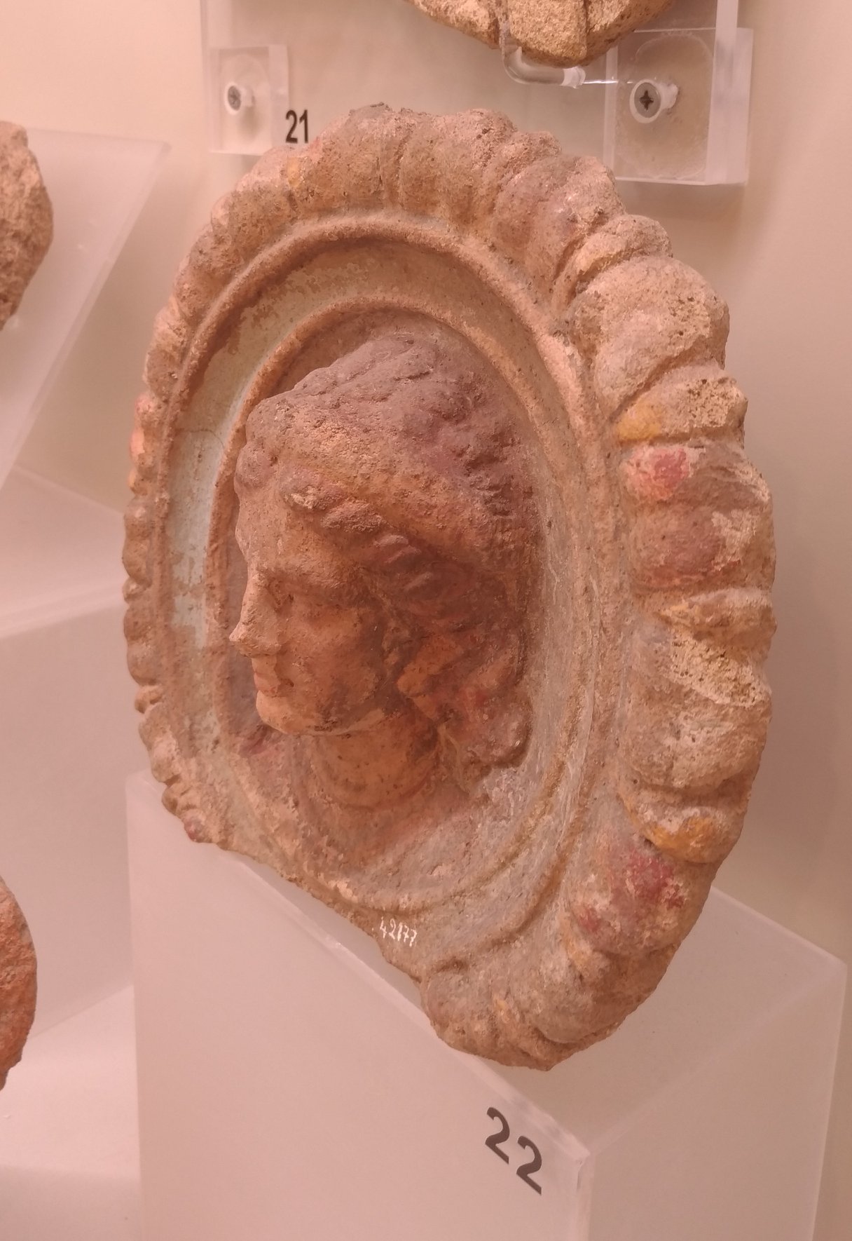 Antefissa a testa di Menade, terracotta plasmata a stampo e dipinta, inv. 42177. 300 a.C. Vulci, fra l’area della città e il Ponte della Badia, scavi Bendinelli 1921, sala 5